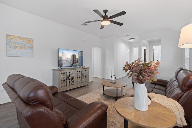 living area with wood finished floors, a ceiling fan, and baseboards