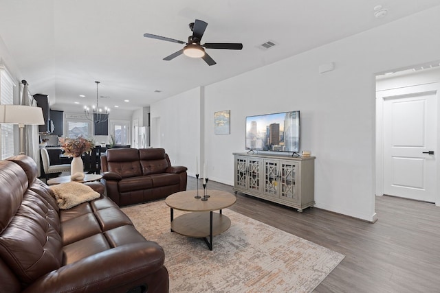 living room featuring a chandelier, wood finished floors, a ceiling fan, baseboards, and recessed lighting