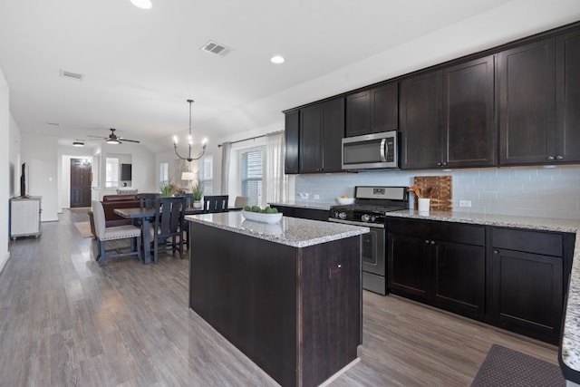 kitchen with appliances with stainless steel finishes, healthy amount of natural light, light wood finished floors, backsplash, and recessed lighting