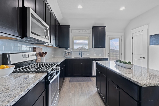 5837 Urbano Bnd, Round Rock, TX 78665 - kitchen with stainless steel appliances, dark cabinets, light wood finished floors, decorative backsplash, and recessed lighting