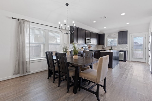 dining area featuring a chandelier, light wood-type flooring, baseboards, and recessed lighting