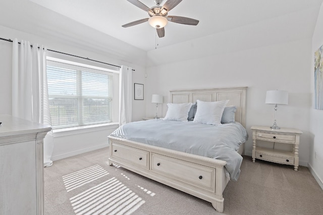 bedroom with light colored carpet, baseboards, and a ceiling fan