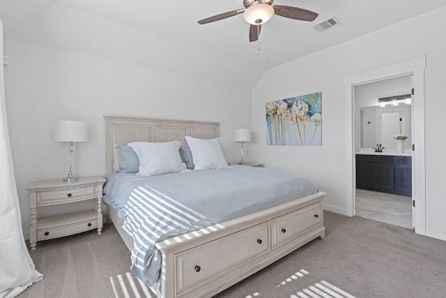 bedroom featuring light carpet, lofted ceiling, connected bathroom, baseboards, and ceiling fan