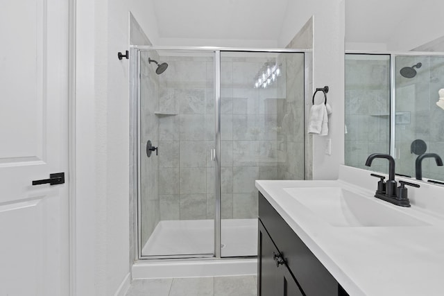 bathroom with a stall shower, tile patterned flooring, and vanity