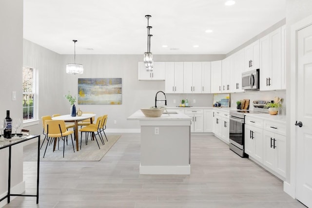 137 Puu Waa Waa Ln, Bastrop, TX 78602 - kitchen featuring appliances with stainless steel finishes, a kitchen island with sink, light countertops, recessed lighting, and white cabinetry