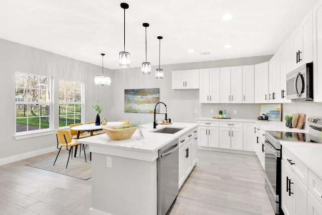 137 Puu Waa Waa Ln, Bastrop, TX 78602 - kitchen with stainless steel appliances, recessed lighting, white cabinetry, a kitchen island with sink, and decorative light fixtures