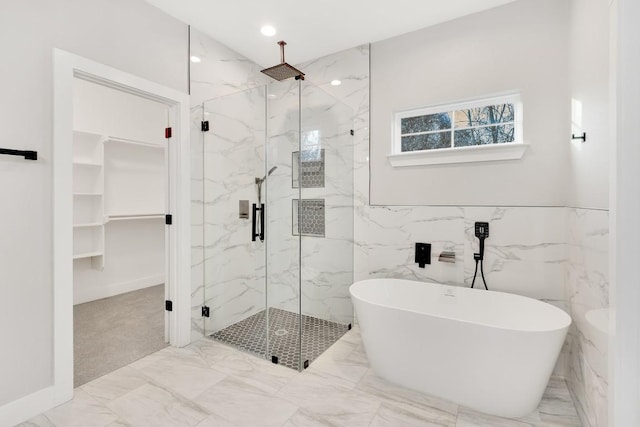 137 Puu Waa Waa Ln, Bastrop, TX 78602 - bathroom featuring a marble finish shower, marble look tiles, a freestanding tub, and a spacious closet