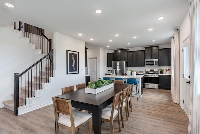 dining area featuring stairway, light wood-type flooring, and recessed lighting