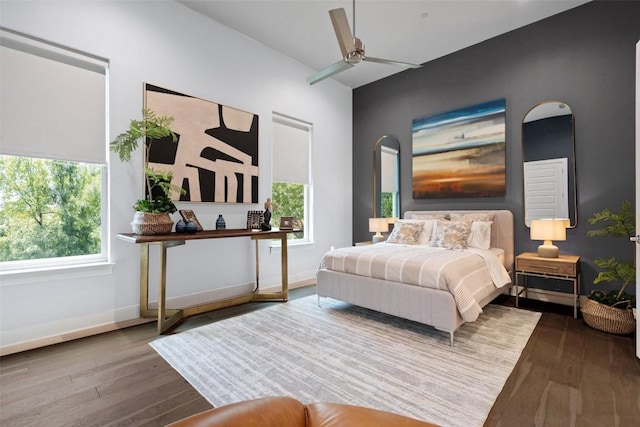 bedroom featuring ceiling fan, baseboards, and wood finished floors