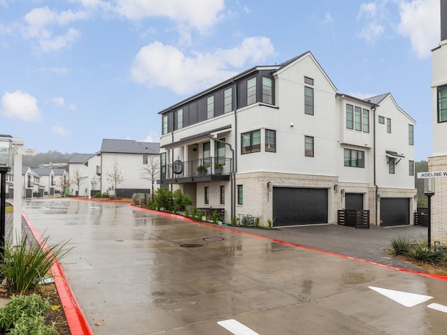 exterior space with a garage, a residential view, and stucco siding