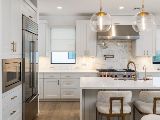 kitchen with stainless steel appliances, light countertops, and white cabinetry