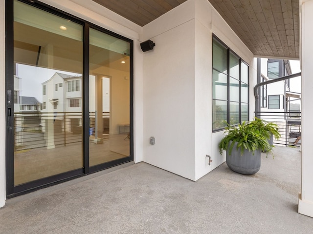 view of exterior entry featuring a balcony and stucco siding