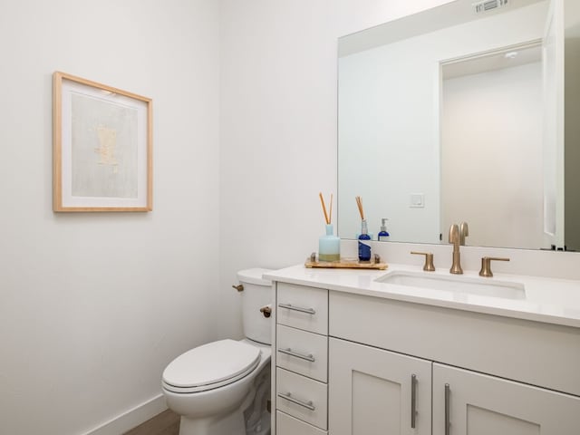 bathroom with toilet, visible vents, baseboards, and vanity