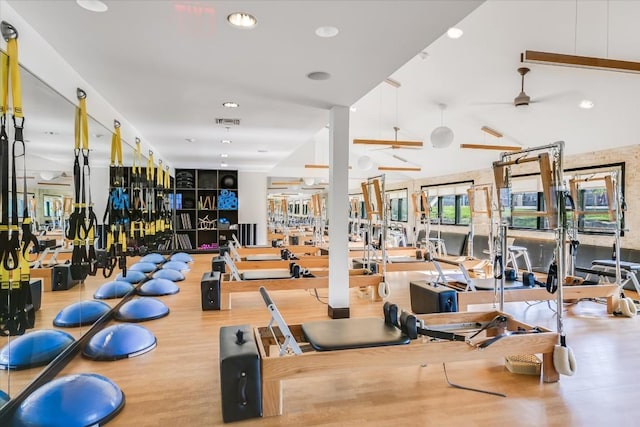 gym with recessed lighting, wood finished floors, visible vents, a ceiling fan, and vaulted ceiling