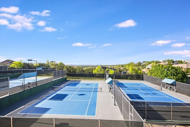 view of tennis court featuring fence