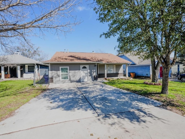 single story home featuring brick siding, concrete driveway, and a front yard