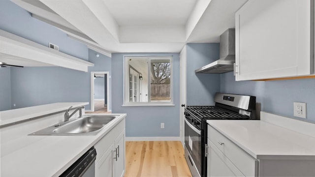1112 Village Green Dr, Austin, TX 78753 - kitchen featuring stainless steel appliances, wall chimney range hood, a sink, baseboards, and light countertops