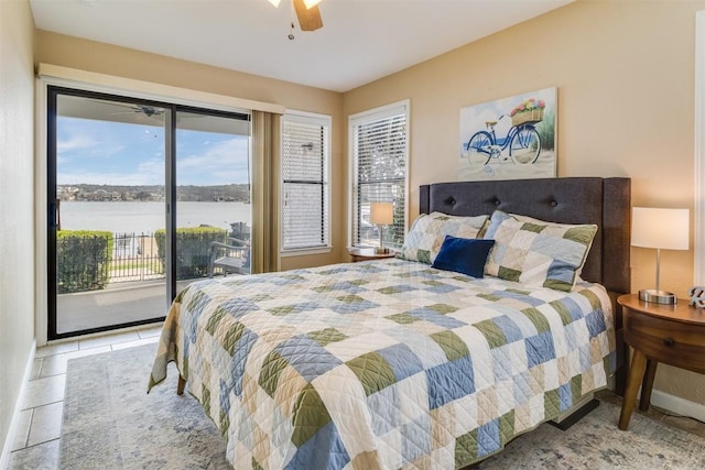 bedroom with access to exterior, light tile patterned flooring, a water view, and a ceiling fan