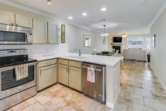 kitchen with stainless steel appliances, a peninsula, a sink, open floor plan, and light countertops