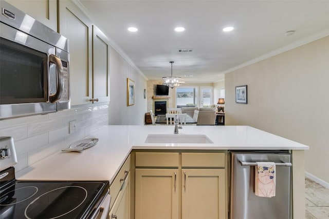 kitchen featuring visible vents, appliances with stainless steel finishes, light countertops, and a sink