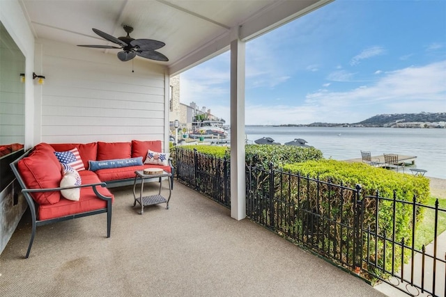 balcony featuring an outdoor hangout area, ceiling fan, and a water view