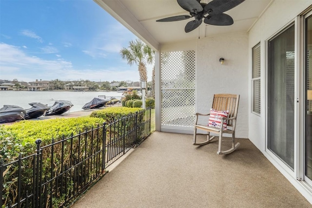 balcony featuring a water view, a sunroom, and ceiling fan