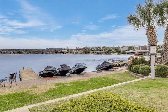 view of dock featuring a lawn and a water view