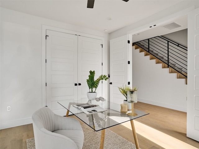 sitting room featuring baseboards, visible vents, a ceiling fan, stairway, and light wood-type flooring