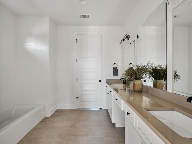 bathroom featuring double vanity, a bathtub, a sink, and visible vents