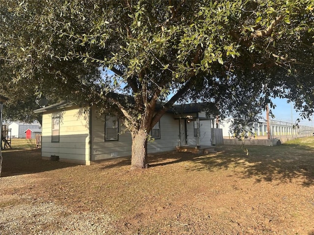 view of front of property with crawl space and fence