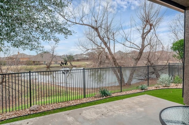 view of patio / terrace featuring a water view and a fenced backyard