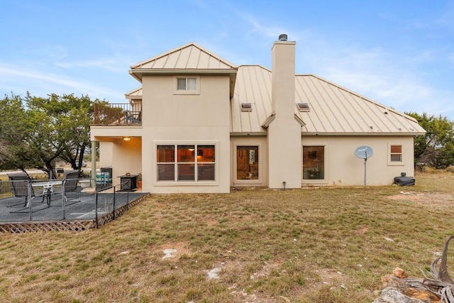 2900 Hi Mesa, Horseshoe Bay, TX 78657 - rear view of house featuring metal roof, a standing seam roof, a yard, and a balcony