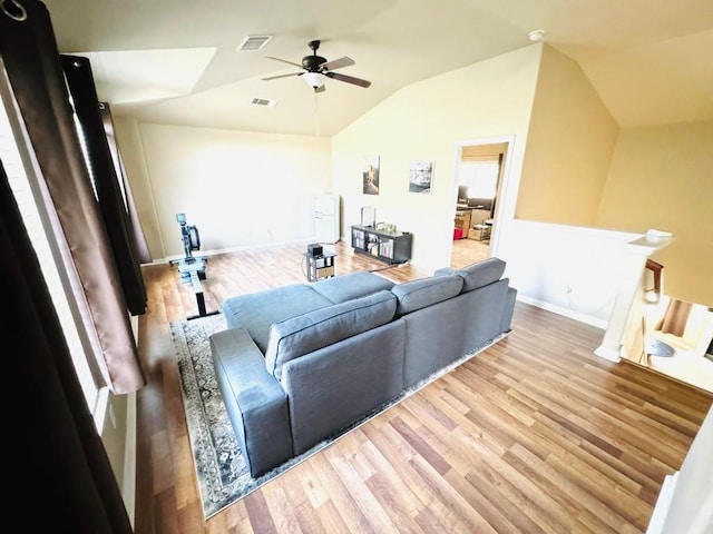 living room featuring visible vents, baseboards, ceiling fan, vaulted ceiling, and light wood-type flooring