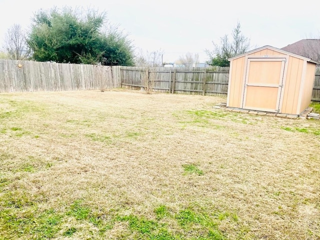 view of yard with a fenced backyard, an outdoor structure, and a storage shed