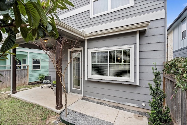 entrance to property featuring a patio area and fence