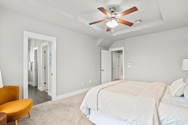 bedroom with baseboards, visible vents, a raised ceiling, a ceiling fan, and dark carpet