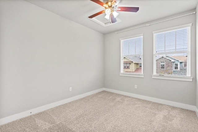 carpeted empty room featuring a ceiling fan and baseboards