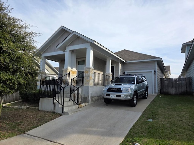 craftsman inspired home featuring an attached garage, covered porch, driveway, board and batten siding, and a front yard