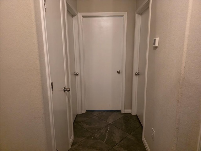 hallway with dark tile patterned flooring