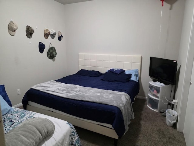 bedroom featuring dark colored carpet and baseboards