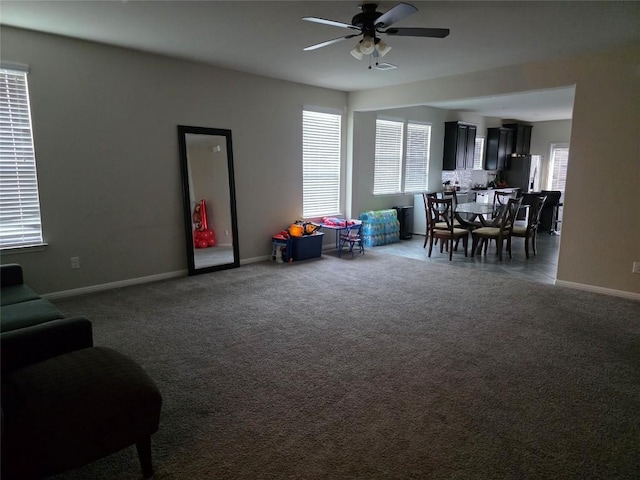 game room featuring a ceiling fan, dark colored carpet, visible vents, and baseboards