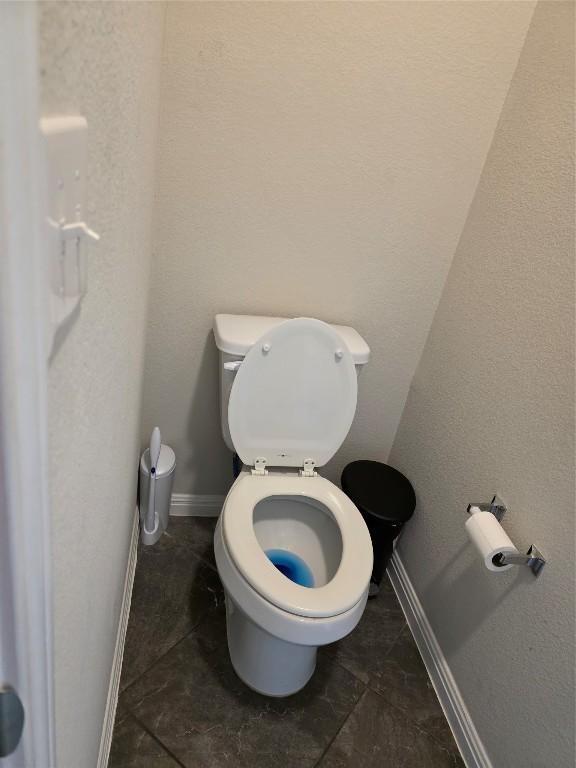 bathroom with toilet and baseboards