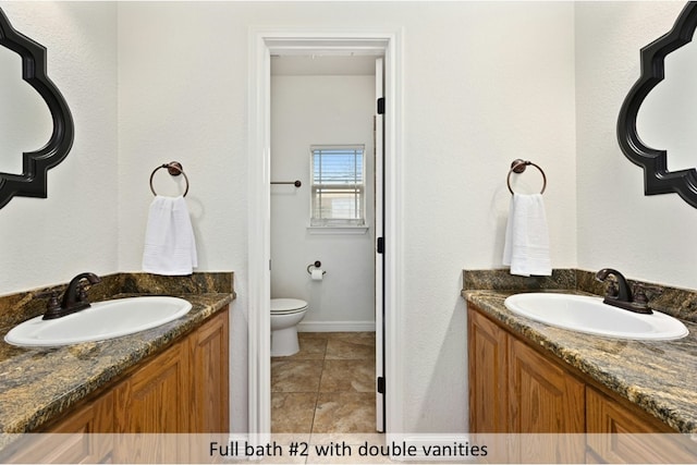 bathroom featuring a sink, two vanities, tile patterned floors, and toilet