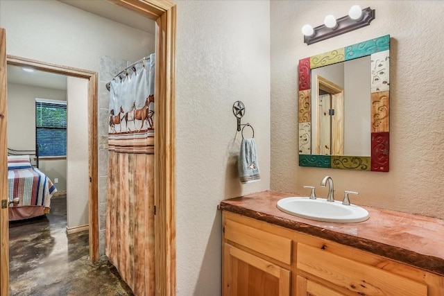 542 Stars And Stripes, Fischer, TX 78623 - ensuite bathroom with connected bathroom, finished concrete flooring, vanity, and a textured wall