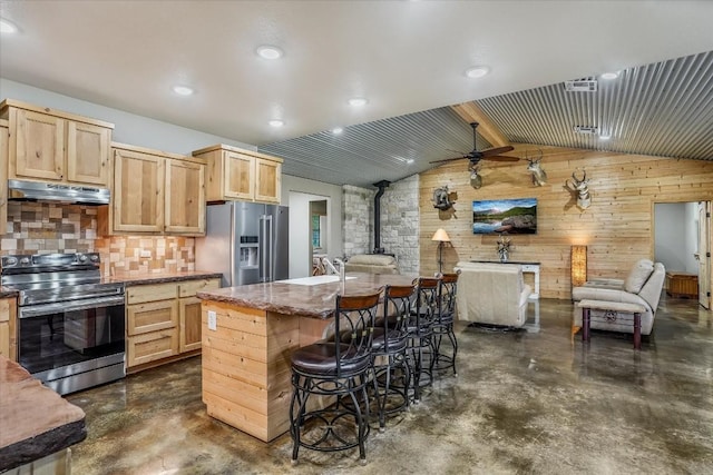 542 Stars And Stripes, Fischer, TX 78623 - kitchen with under cabinet range hood, a wood stove, concrete floors, and appliances with stainless steel finishes