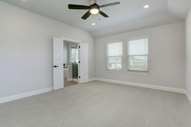 unfurnished bedroom featuring lofted ceiling, light colored carpet, baseboards, and recessed lighting