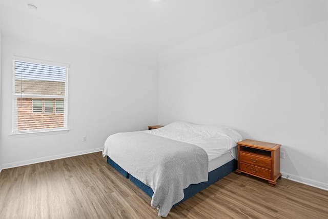 bedroom featuring wood finished floors and baseboards