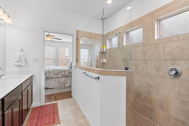 full bath with a walk in shower, tile patterned flooring, vanity, a ceiling fan, and ensuite bath