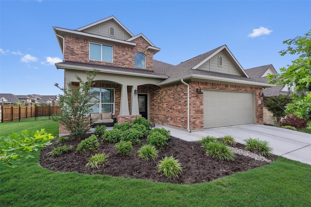 traditional-style house featuring brick siding, fence, a front yard, and concrete driveway