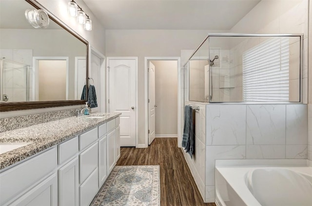 1330 Logan Blvd, Salado, TX 76571 - bathroom featuring wood finished floors, a stall shower, a bath, double vanity, and baseboards